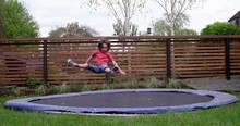Young Girl Doing Tricks On Her Trampoline In Her Garden, In Slow Motion