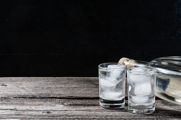 Cold vodka in shot glasses on a black background