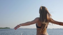Young Woman Into Bathing Suit With Sexy Body Enjoys Of Freedom And Raising Hands Up On Nature In Summer Season, Luxurious Hair Waving In Wind