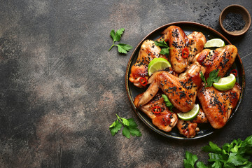 Wall Mural - Grilled teriyaki chicken wings with black sesame and lime.Top view with copy space.