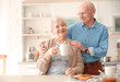 © New Africa - Elderly couple having breakfast in kitchen