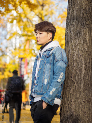 Young Chinese Smiling Man Portrait Stand With Blur Yellow Trees Background In Sunset In Autumn Park Outdoor Stock Photo Adobe Stock