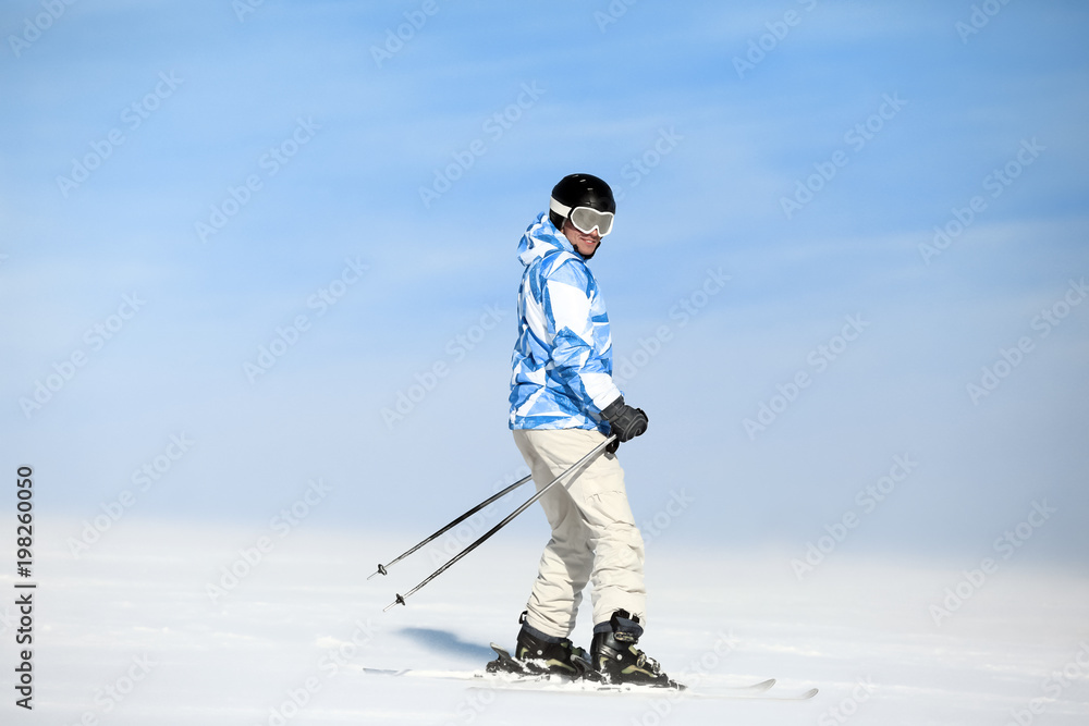 Man skiing on piste at snowy resort. Winter vacation