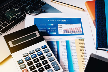 Loan concept, Loan Calculator paper with calculator, computer labtop, notebook and smart phone on the table.