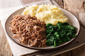 Botswana festive meal: seswaa stewed beef with pap porridge and spinach close-up on a plate. horizontal