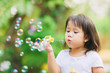 © nateejindakum - Outdoors activity : Cute kid blowing bubbles soap in the  garden. Picture for concept of childhood in school age.