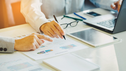 Two businessman investment consultant analyzing company financial report balance sheet statement working with documents graphs. Concept picture for stock market, office, tax, and project.