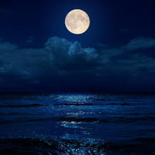 Full Moon In Night Over Clouds And Sea With Reflections