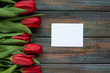 Red tulips and empty card for your text