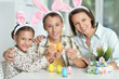 © aletia2011 - Mother with her son and daughter painting eggs for Easter