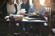 © Mladen - Three students girls teaching in cafe. Focus on foreground.