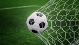Fototapeta Sport - Soccer ball on goal with net and green background