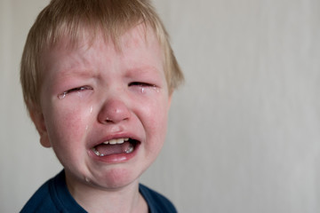 Cry. Portrait of boy. Caucasian child looks at camera. Charming boy the kid cries with tears in his eyes. an angry temper. hysterics.