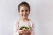 © kaganskaya115 - Happy little girl eating fresh vegetables. A portrait on a white background.