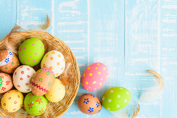 Happy easter! Colorful of Easter eggs in nest on pastel color bright green and white wooden background.