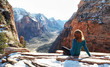 © Ben Sandall - Redhead woman enjoying mountain view while sitting on rocks
