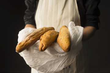 Wall Mural - Conceptual art photography of a old woman hands hold the baguette bread wrapped in white cloth