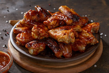 Grilled Chicken Wings With Bbq Sauce On The Clay Plate On The Table.