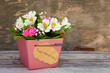 Box with flowers on old wooden background. Concept of greeting Happy Mother's Day.