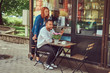© Fxquadro - A couple dating drinking coffee, sitting near the coffee shop. Outdoors on a date.