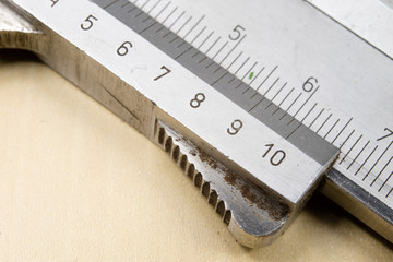 Measuring tools in the workshop. Caliper for locksmith work on a wooden table.