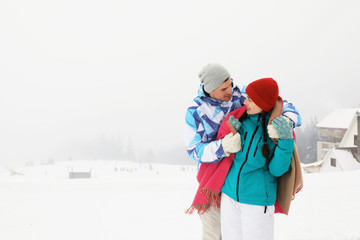 Canvas Print - Lovely couple at snowy resort. Winter vacation