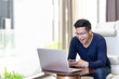 © ChayTee - Happy excited asian man celebrate with smartphone and computer laptop, success or happy action. Freelancer or Entrepreneur using technology and start up modern office with copy space