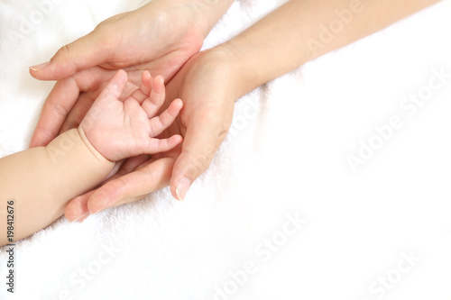 小さな赤ちゃんの手を母が両手で包むイメージ Stock 写真 Adobe Stock