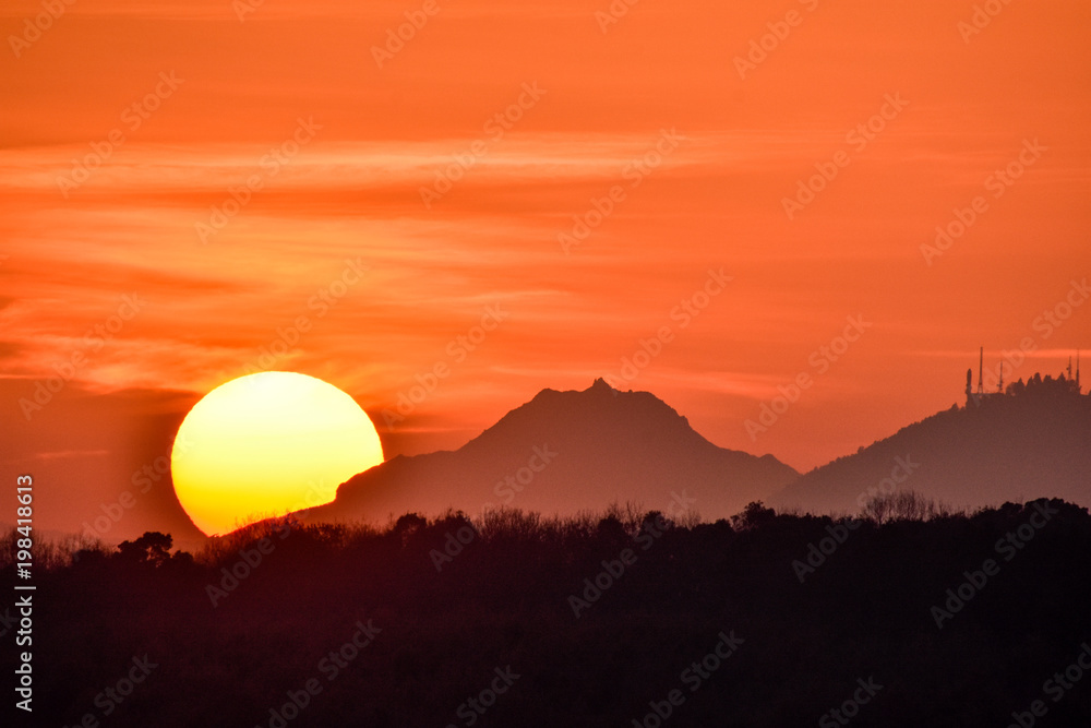 夕日写真 雲仙普賢岳と金峰山に沈む夕日 Sunset over Unzen Futenakake and