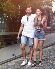 Poster - Cheerful young couple walking on urban street