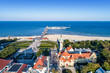Sopot resort in Poland. SPA , old lighthouse, wooden pier (molo) with marina, yachts,  beach,  vacation infrastructure, park, promenade and walking people.  Aerial view.