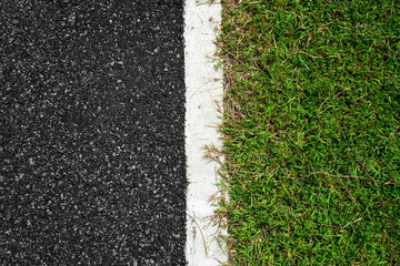 Asphalt road with white lines and green grass background.