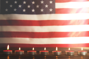 Wall Mural - Mourning candles burning on USA American national flag background. Memorial weekend, patriot veterans day, 9/11 National Day of Service & Remembrance. Moment of silence concept. Close up, copy space.