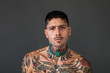 Handsome bare-chested tattooed man portrait looking at camera