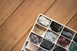 Collection of minerals in box on wooden background