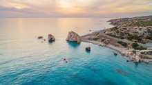 Aerial Bird's Eye View Of Petra Tou Romiou, Aka Aphrodite's Rock A Famous Tourist Travel Destination Landmark In Paphos, Cyprus. The Sea Bay Of Goddess Afroditi Birthplace At Sunset From Above.