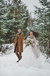 © alenazamotaeva - Newlyweds walk among snow-covered trees and pines 841.