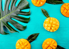 Creative Layout Made Of Summer Tropical Fruits Mango And Tropical Leaves On Turquoise Background. Flat Lay. Food Concept. Tropical Concept