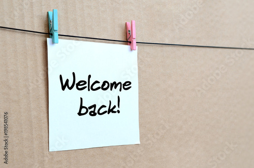 Fotografie, Obraz Welcome back! Note is written on a white sticker that hangs with a clothespin on