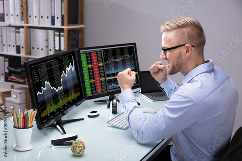 Fotomural Excited Stock Market Broker Looking At Graph On Computer