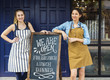 © Rawpixel.com - Cheerful business owners standing with open blackboard
