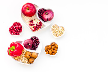 Wall Mural - Diet for healthy heart. Food with antioxidants. Vegetables, fruits, nuts in heart shaped bowl on white background top view copy space