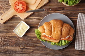 Sticker - Plate with tasty croissant sandwich on table