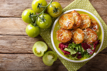 American food: Fried green tomatoes with fresh lettuce close-up on a plate. horizontal top view