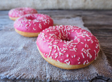 Donuts With Pink Frosting On The Table