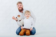 © Iryna - Family portrait of h andsome beard man, his son and jack russel terrier puppy dog on white background.
