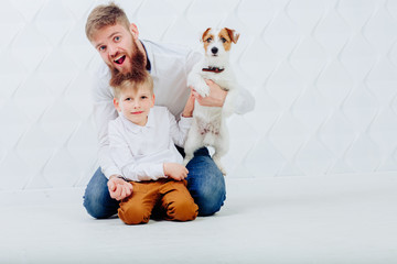 Family portrait of h andsome beard man, his son and jack russel terrier puppy dog on white background.