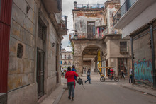 Woman From The Back In A Red Jacket With A Child Walking Down The Street. Havana. Cuba