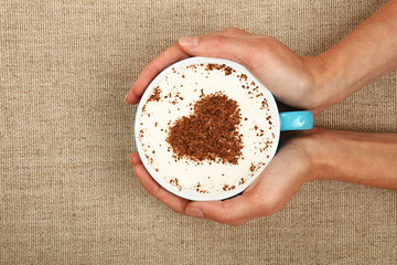 Wall Mural - Woman hands hold full latte cappuccino coffee cup