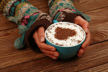 Wall Mural - Woman hands hold full latte cappuccino coffee cup